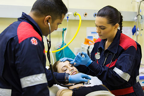 image of two emts looking at a patient