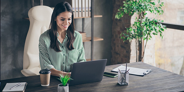 image of woman at desk with a laptop