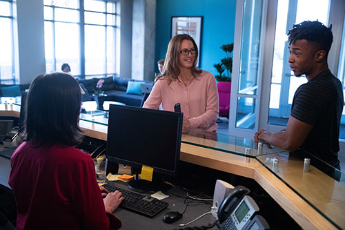 image of an office receptionist and two customers